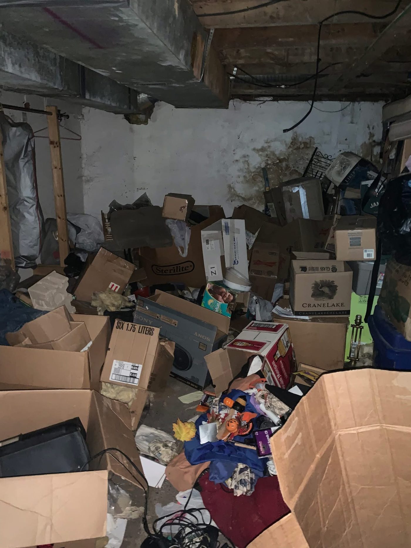 Basement storage room filled with boxes and belongings before a cleanout